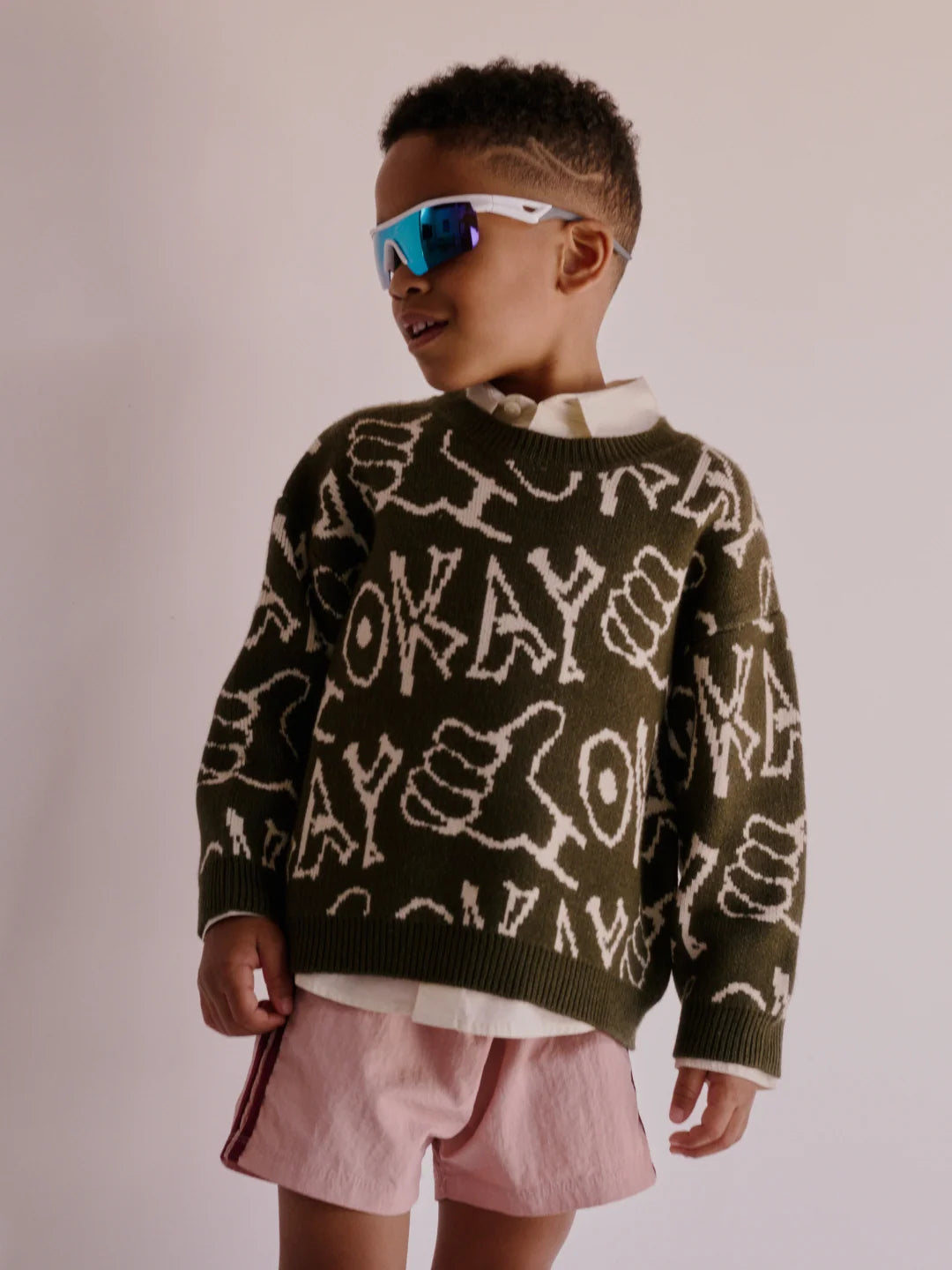 child wearing the okay sweater in green
