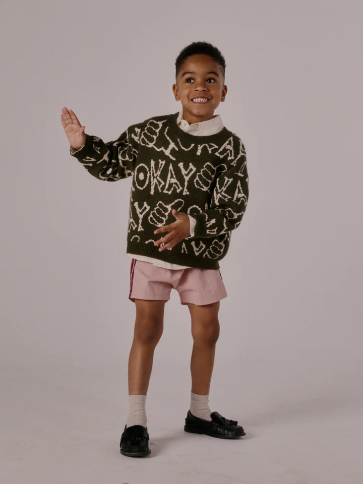 child wearing the okay sweater in green