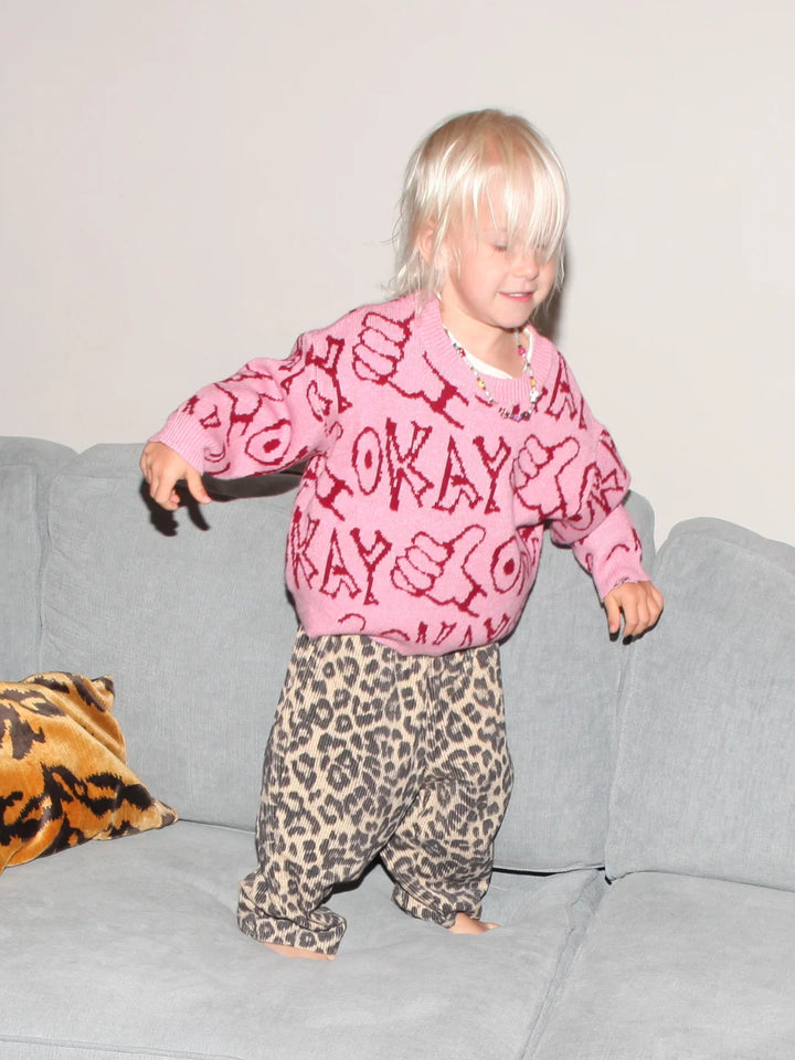 child wearing the okay sweater in pink